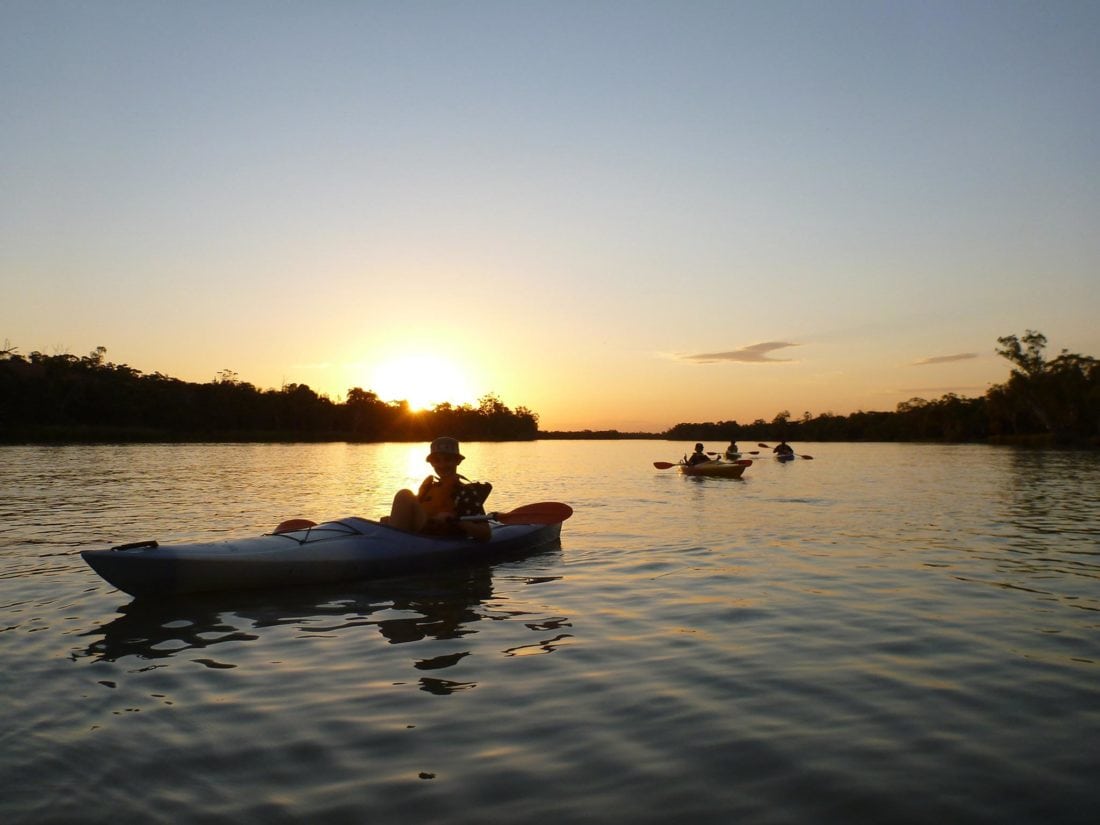 kayakers on the river after sunset