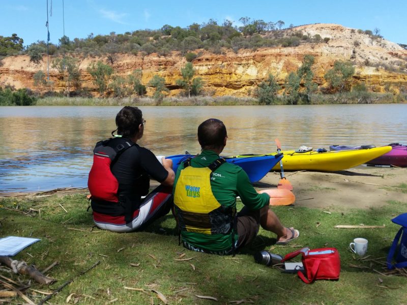 Coffee Break on the waters edge with kayaks and cliffs in view