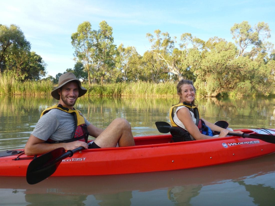 2 kayakers smile at camera, in double hire kayak