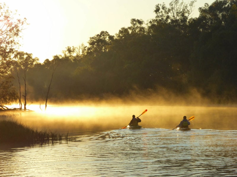 2 kayakers in the mist at sunrise